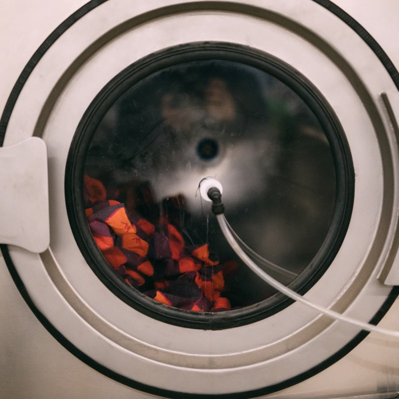 Orange socks being washed in a machine