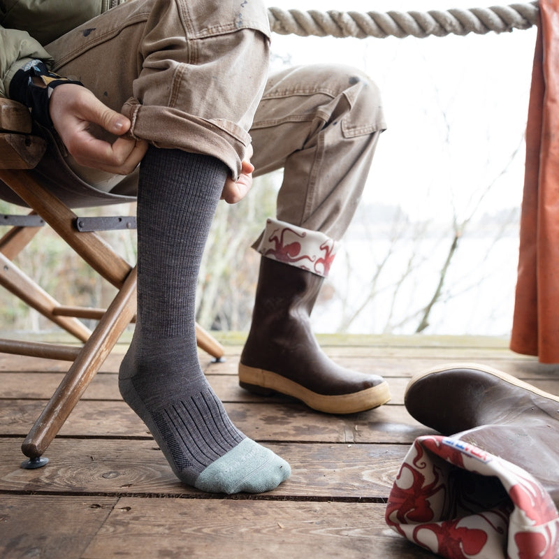 Peron putting on Darn Tough Work Socks and Rubber Boots