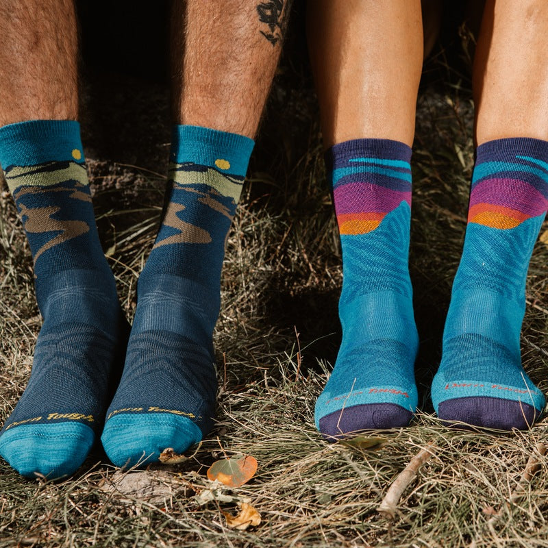 Two people sitting on some hay in Darn Tough Hiking Socks