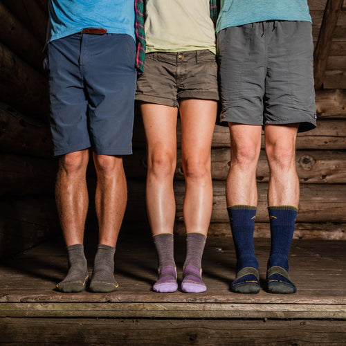 Three people in darn tough socks with different heights but the same performance fit