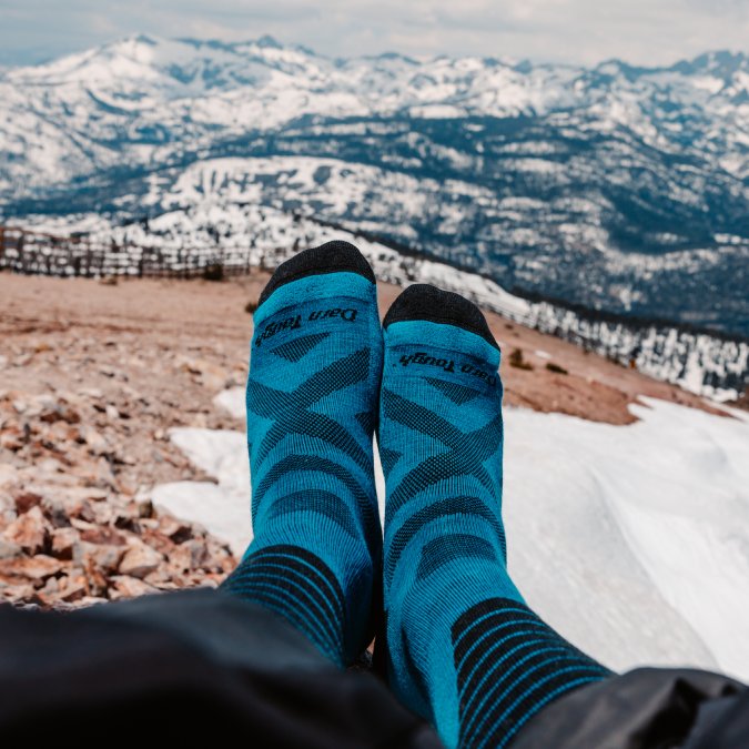 POV shot of someone's feet in Darn Tough Edge Ski socks with mountains in the background
