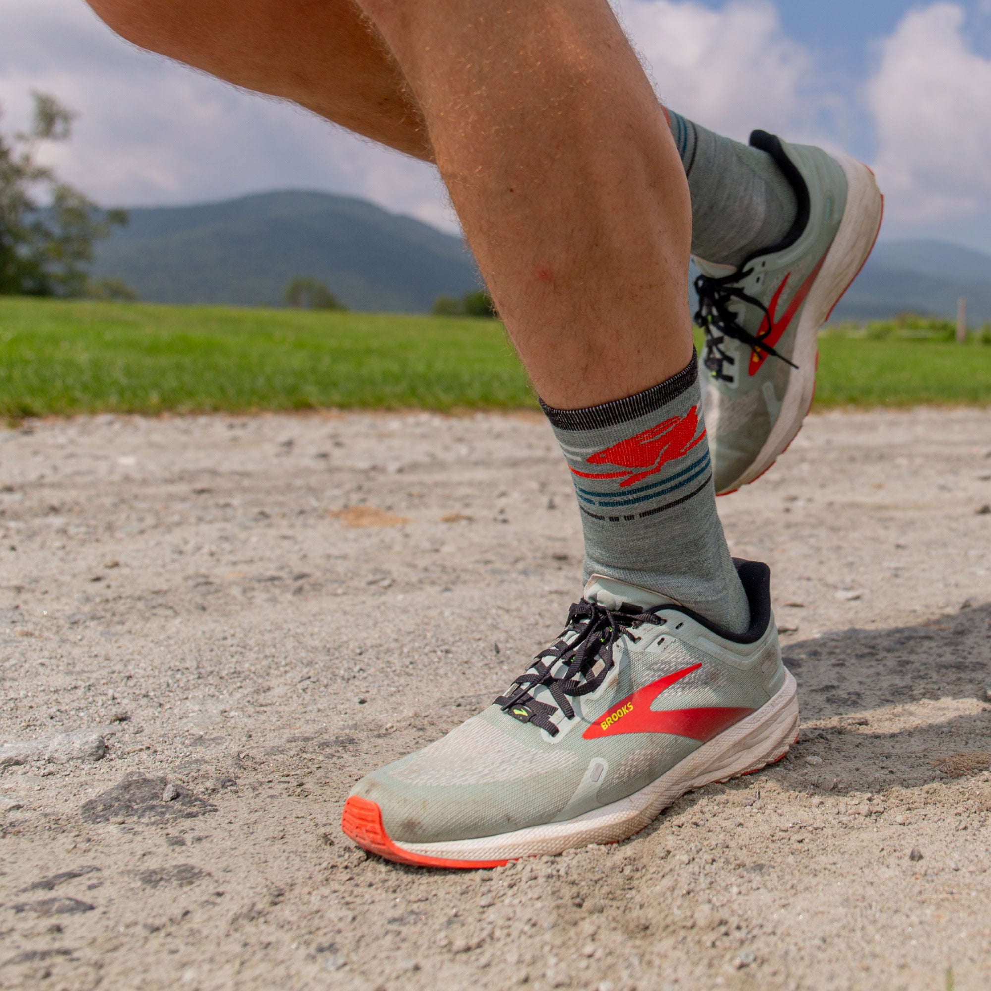 model running on dirt road wearing the 1041 pacer micro crew running sock in seafoam colorway