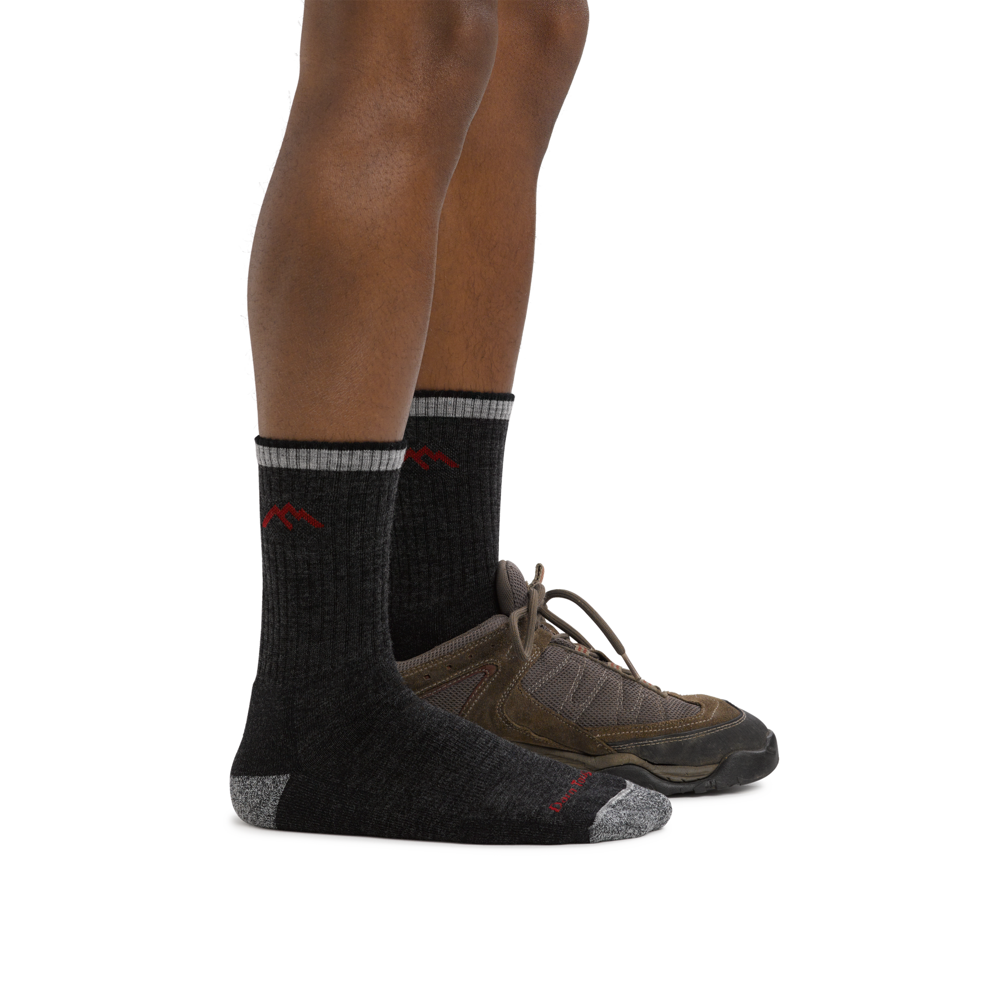 Man wearing Hiker Micro Crew Midweight Hiking Sock in Black, foot in back also wearing a hiking shoe