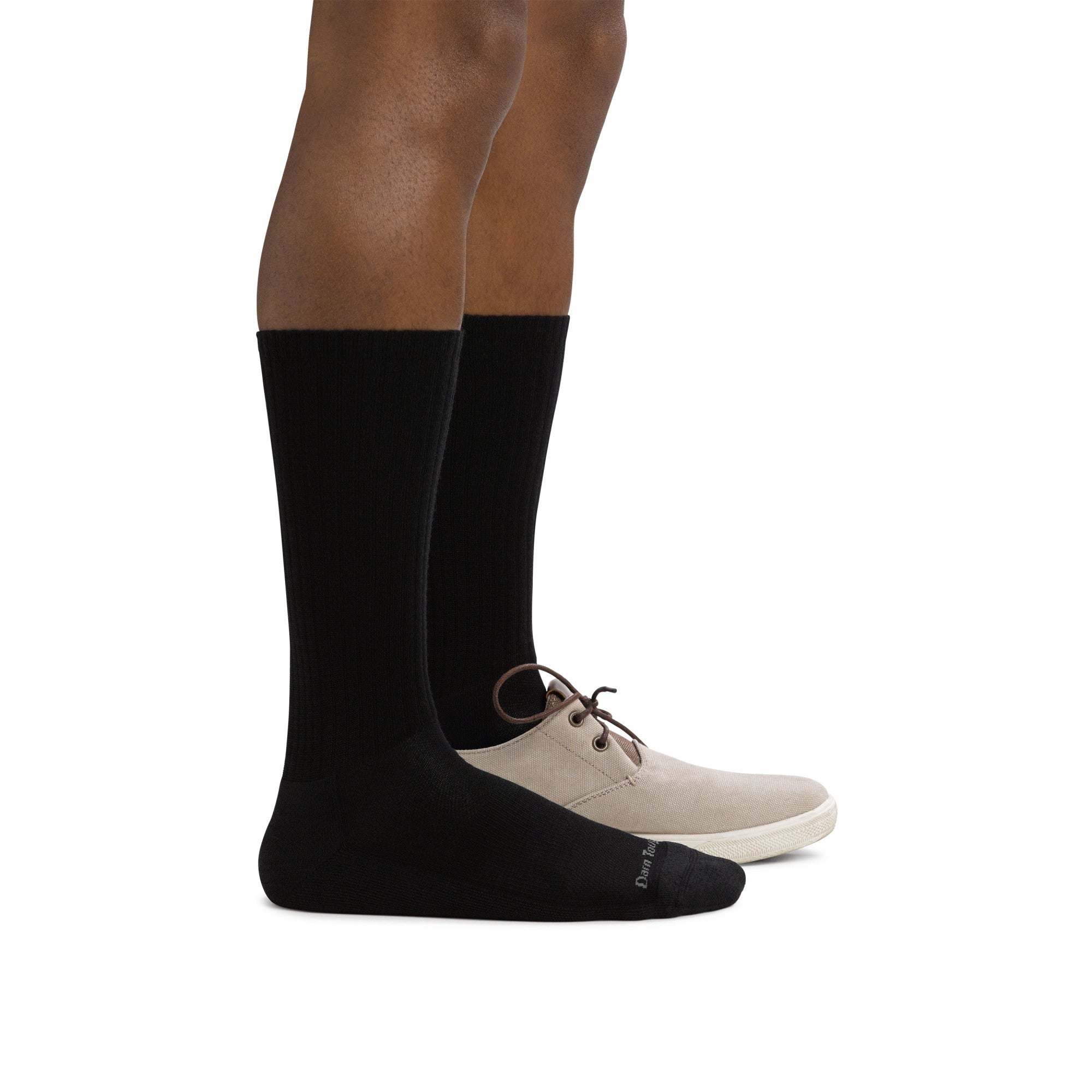 Feet wearing plain black socks that rise just above mid-calf.