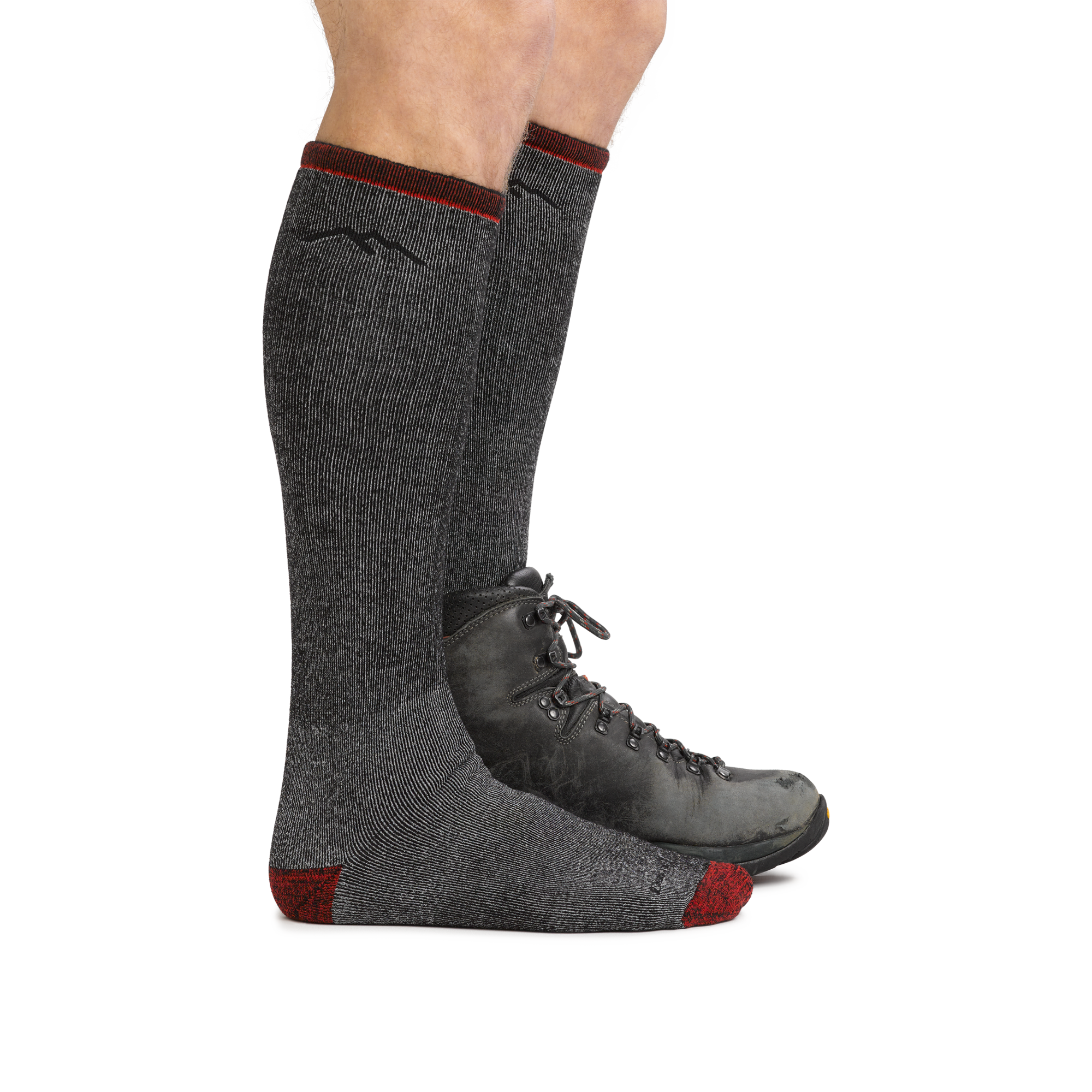Male legs wearing Mountaineering Over the Calf Heavyweight Hiking Sock in Smoke, back foot wearing a hiking boot