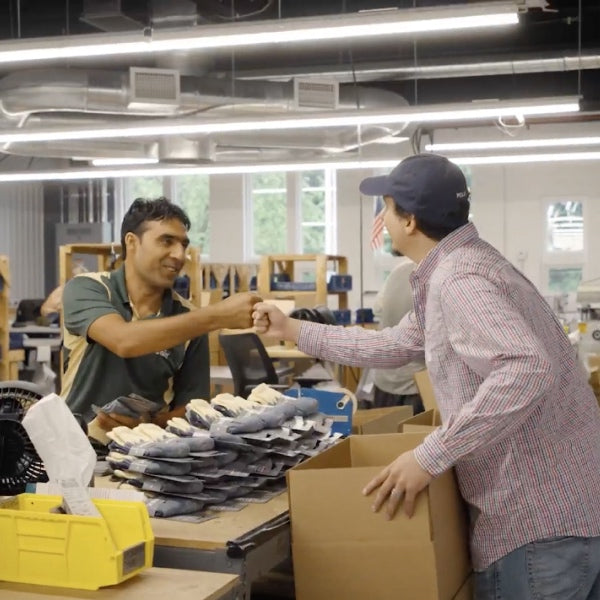 Two employees at Darn Tough giving each other a fist bump