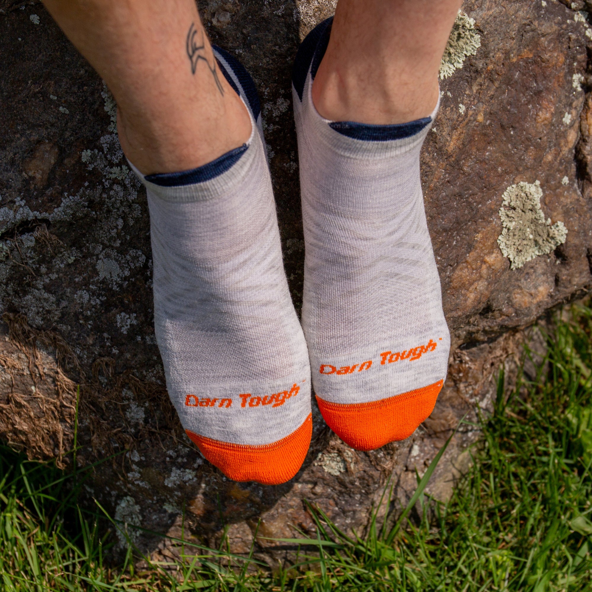 top view of models feet on a rock in the grass wearing the 1039 ultra lightweight no show in Ash 