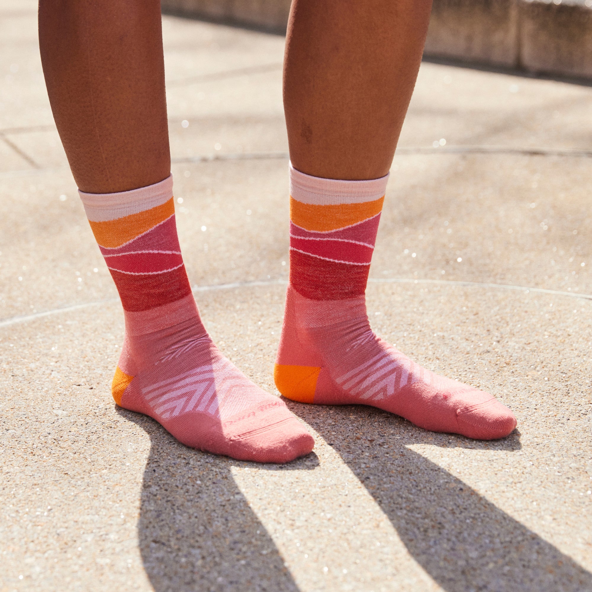 Close up shot of model standing outside on concrete wearing 1064 socks in Canyon colorway without shoes on