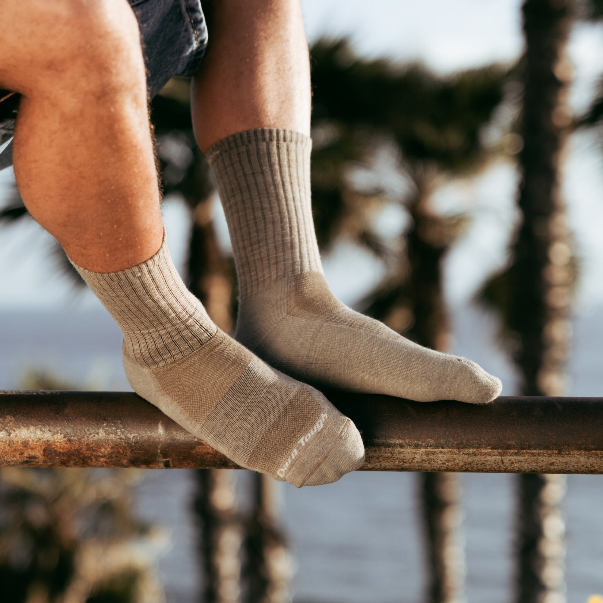 Models feet on metal rail wearing the 1657 Standard crew lifestyle sock in rye colorway