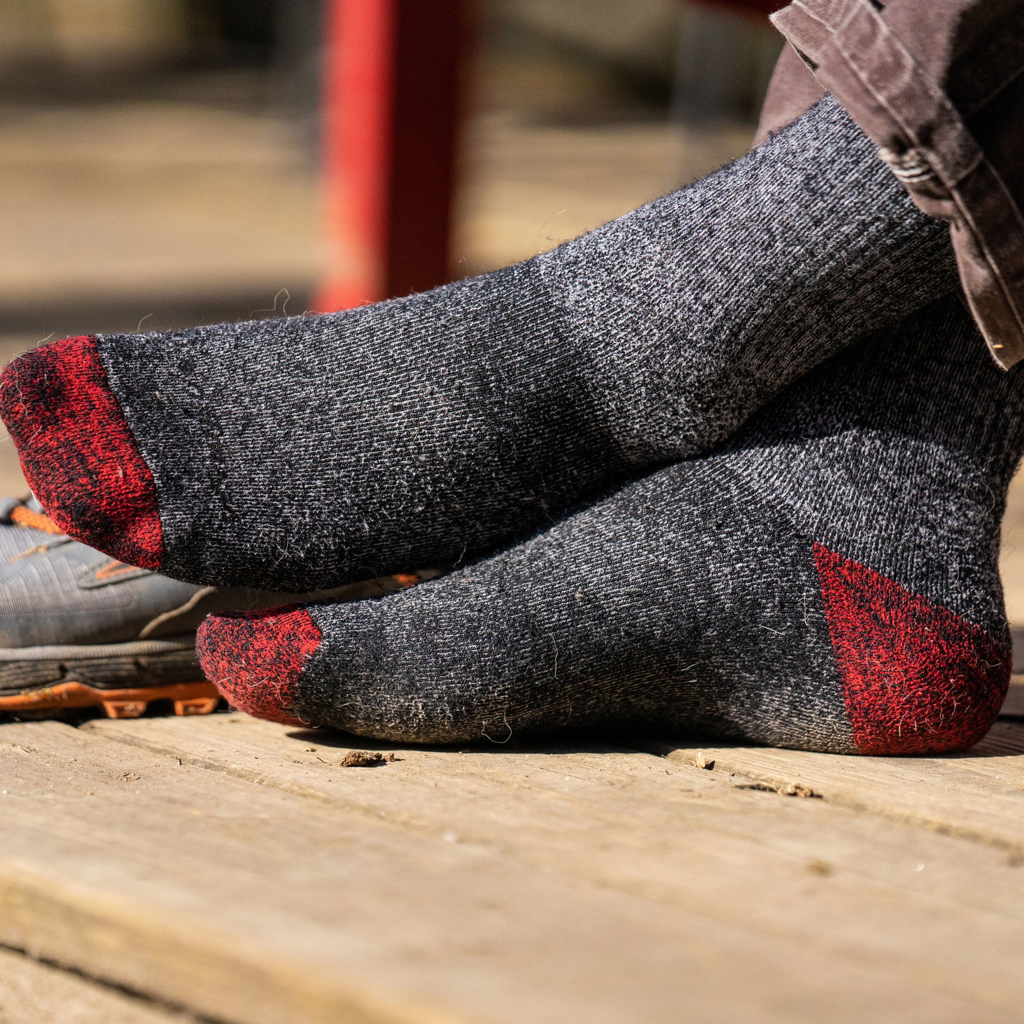 Close up lifestyle image of male feet wearing Mountaineering Over the Calf Heavyweight Hiking Sock in Smoke