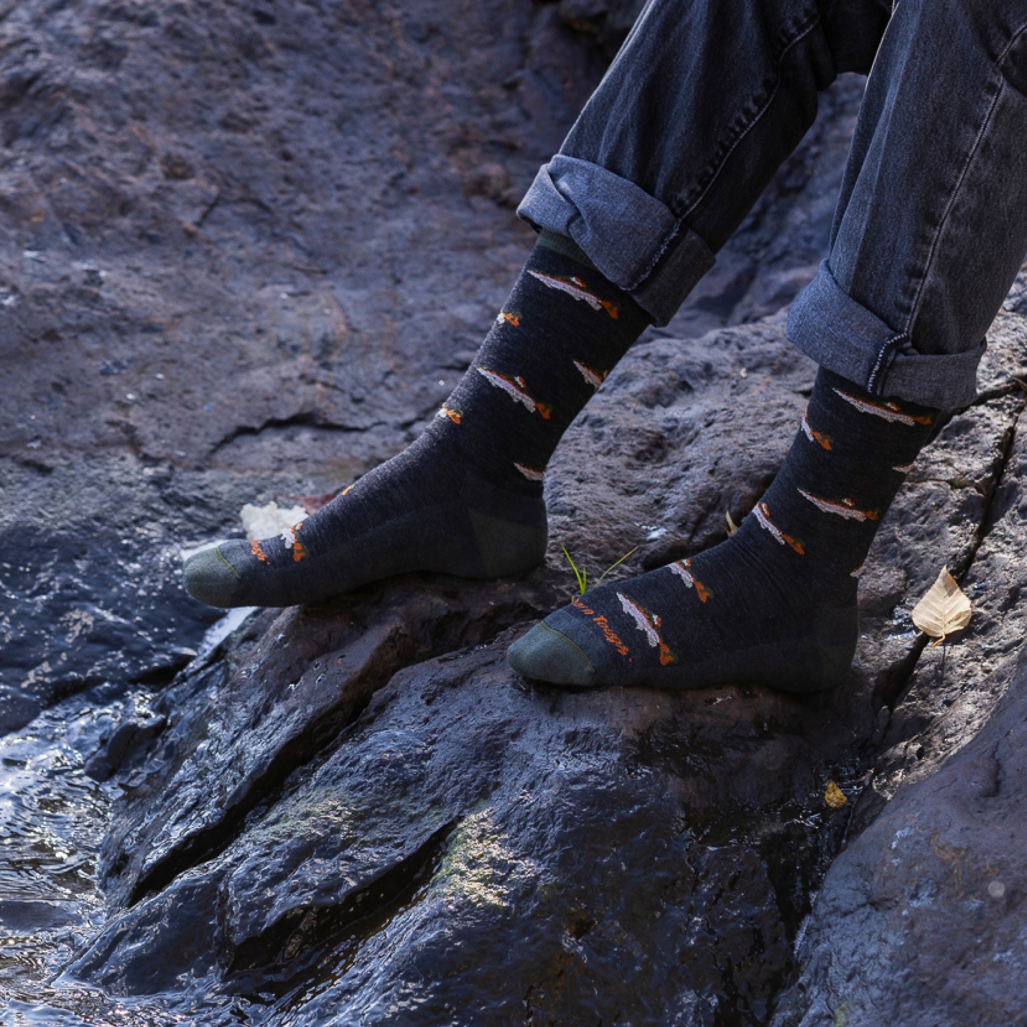 close up of models feet on rocks wearing the 6085 spy fly lightweight lifestyle crew in charcoal colorway