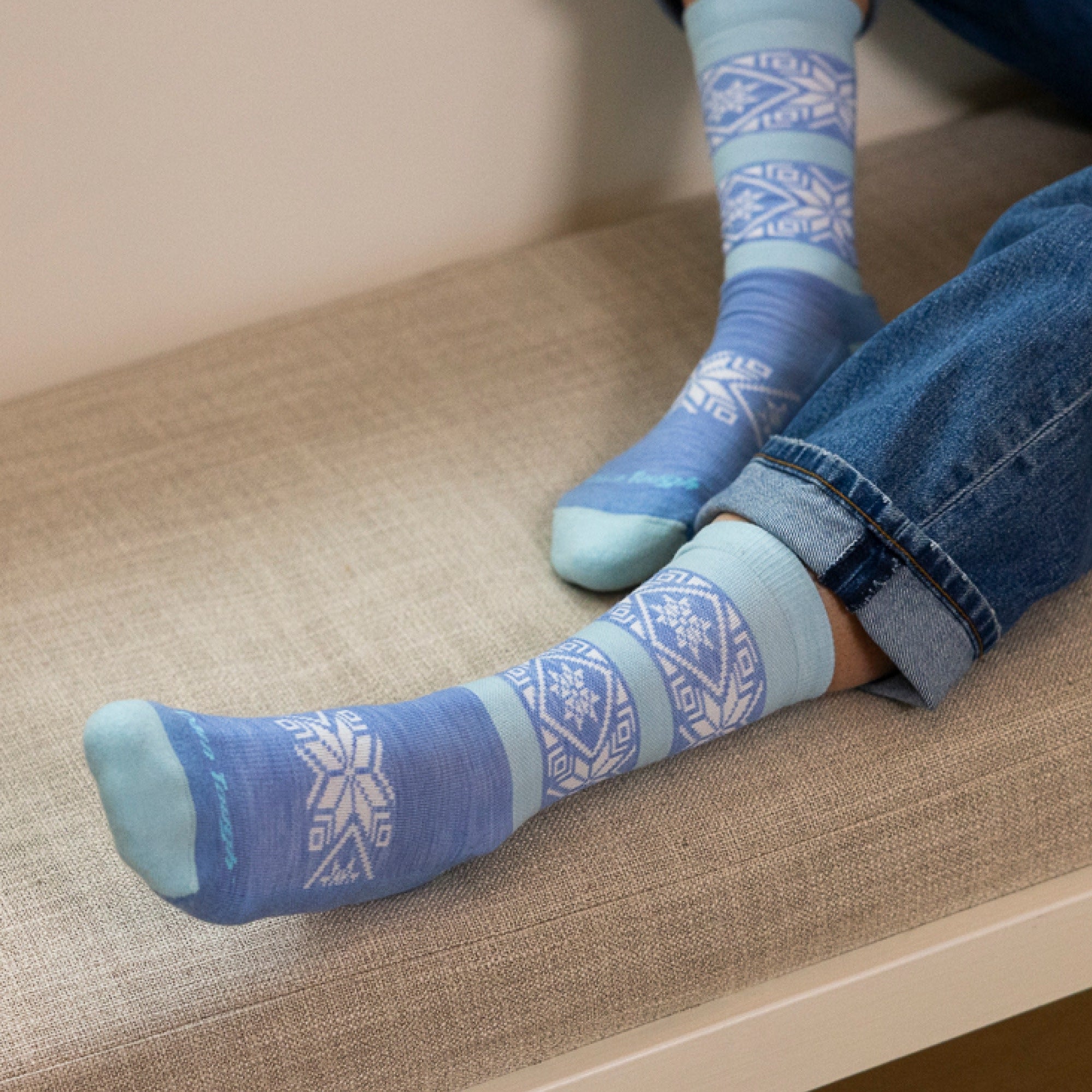 close up image of models feet on couch cushion wearing 6129 elsa crew lightweight with cushion vapor blue sock