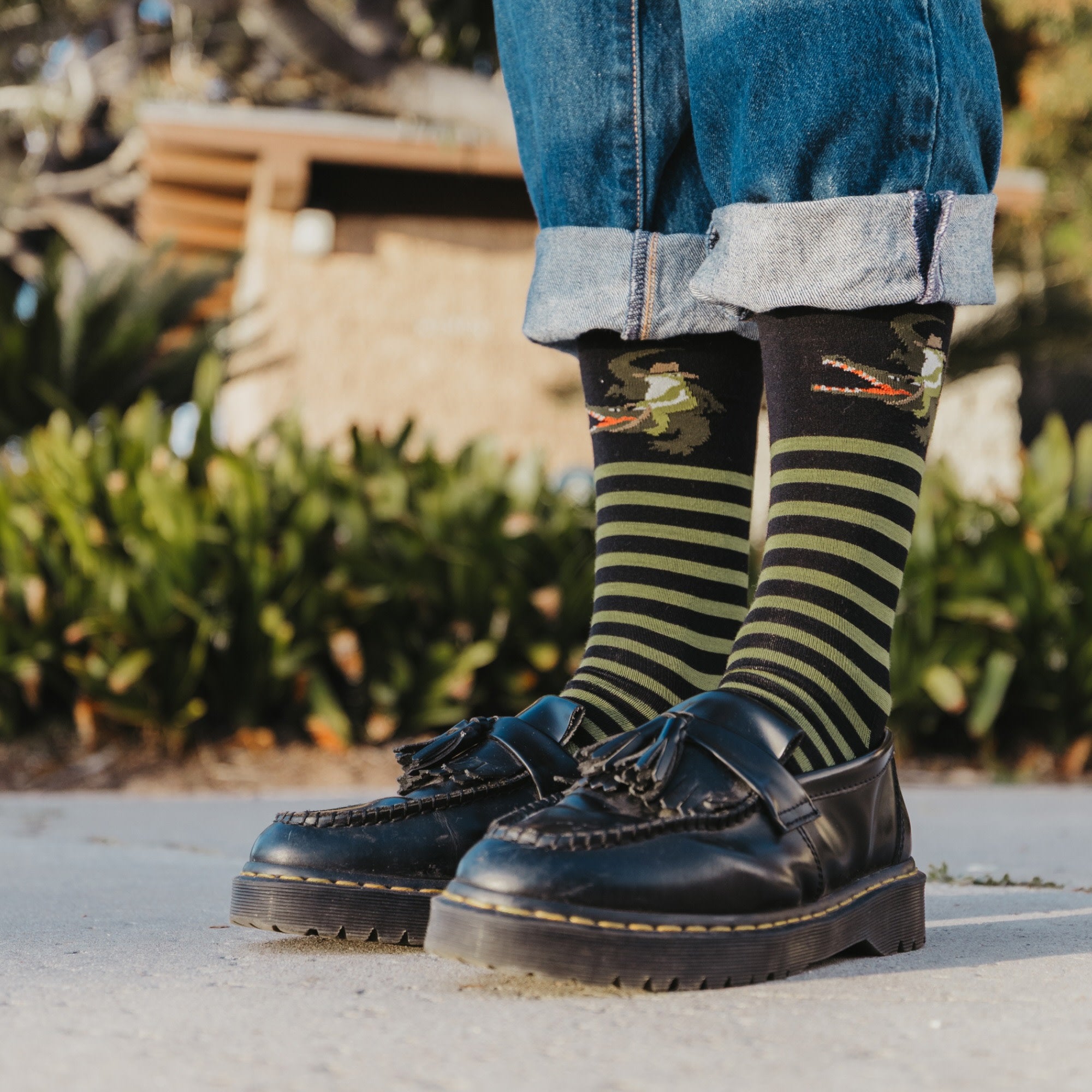 close up of models feet wearing thick soled loafers and 6066 animal haus lightweight lifestyle crew sock in gator green colorway