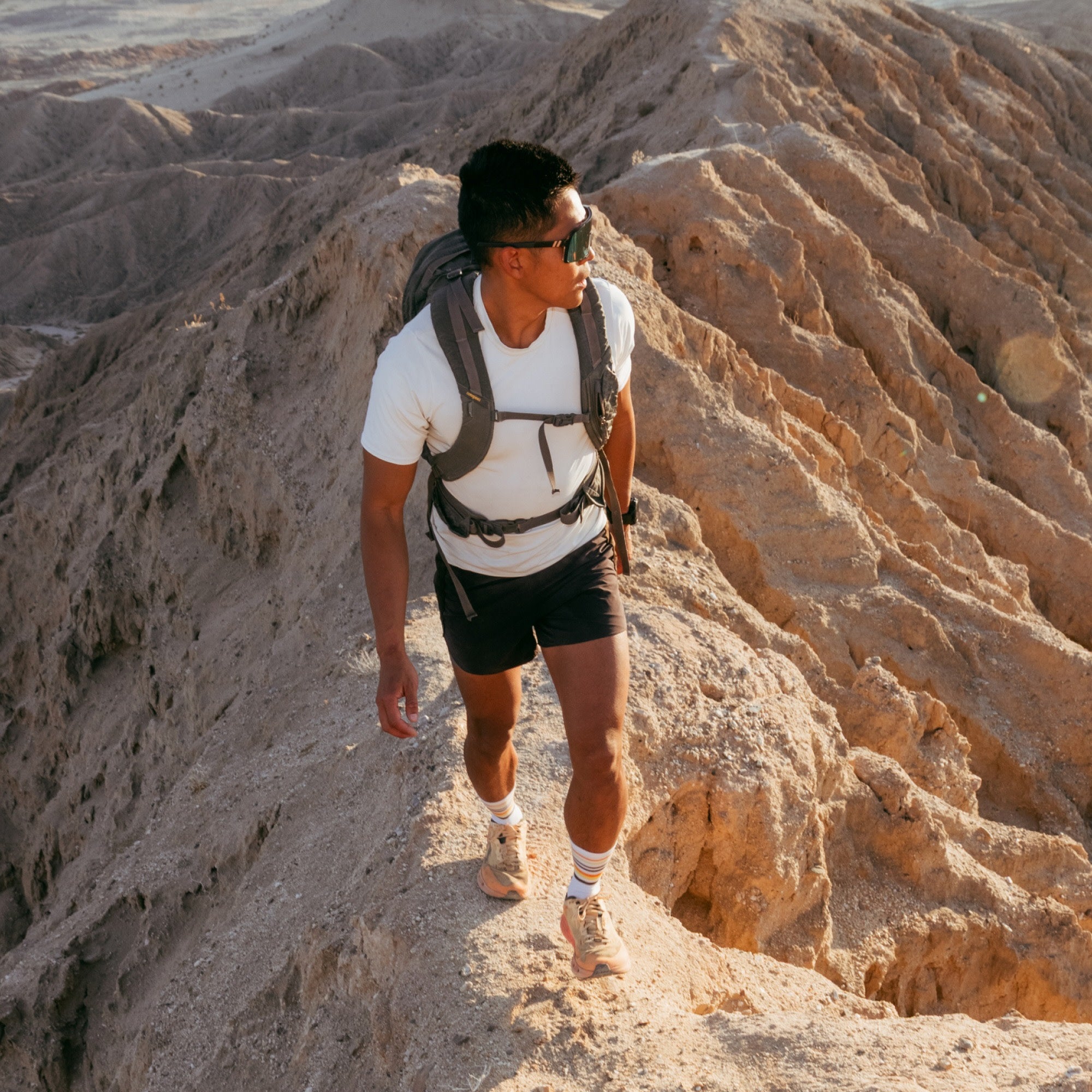 model walking the ridgeline wearing the 5012 fastpack lightweight micro crew hiking sock in white colorway