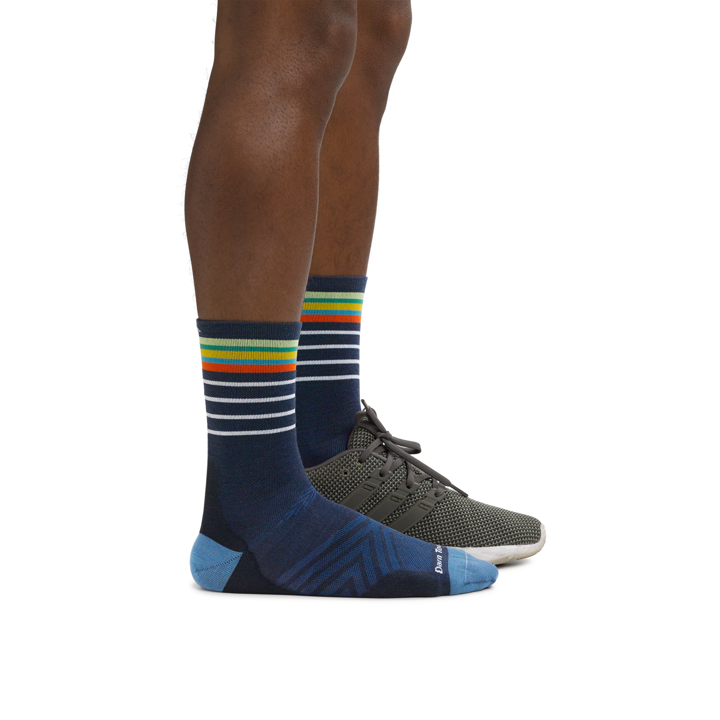 Man wearing Stride Micro Crew Ultra-Lightweight Running Socks in Eclipse with a running shoe on the foot in back