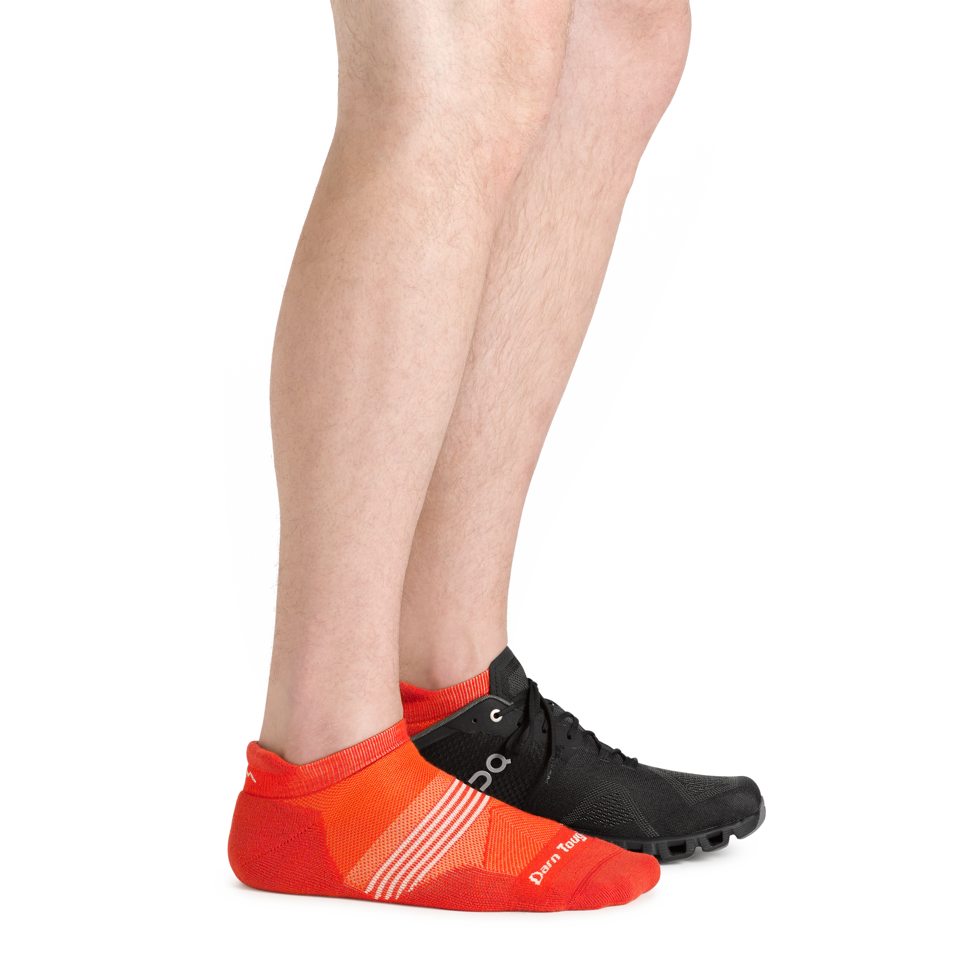 Side shot of model wearing the men's element no show tab running sock in tiger color with a black sneaker on his left foot