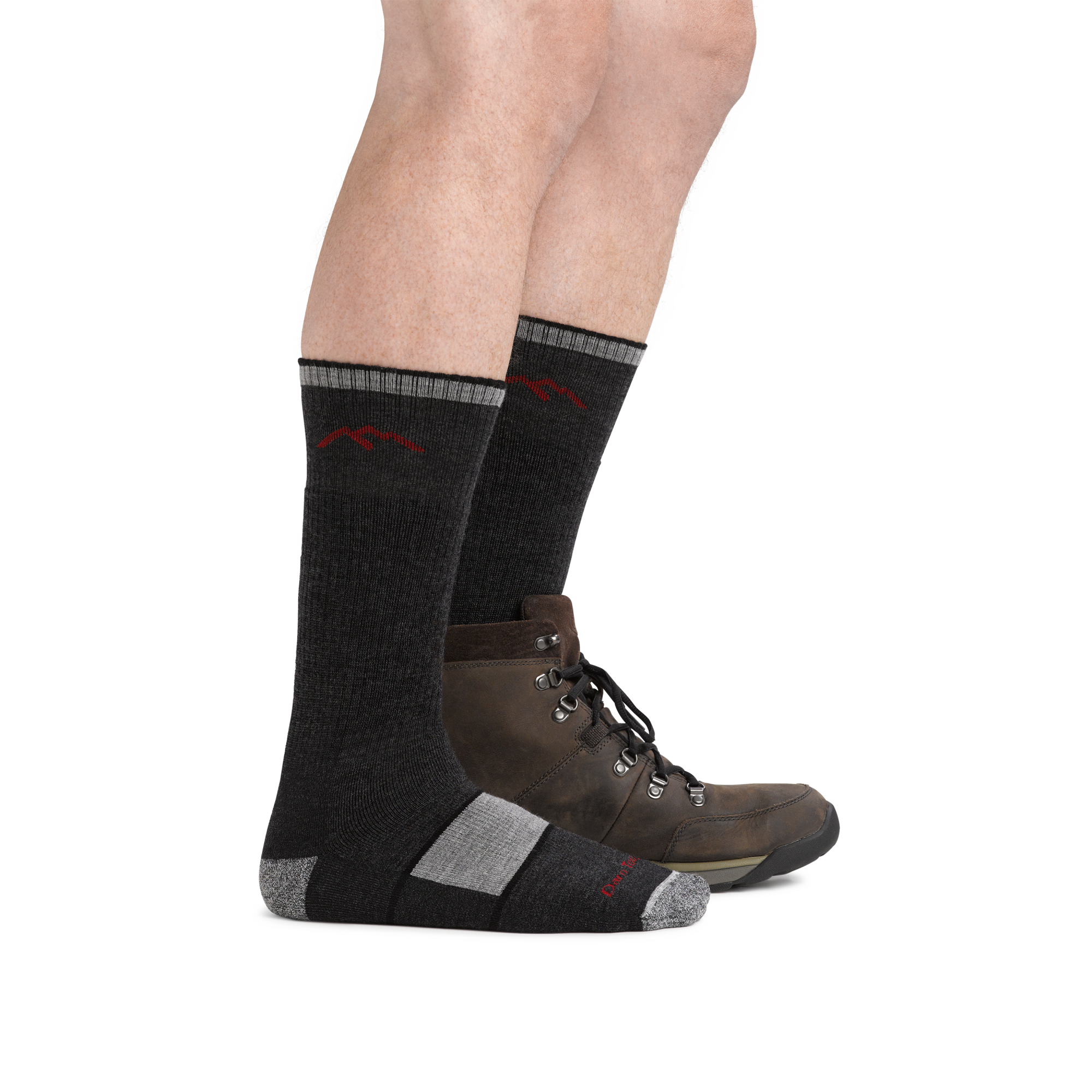 Man wearing Hiker Boot Midweight Hiking Socks with Full Cushion in black, with back foot also wearing a hiking boot