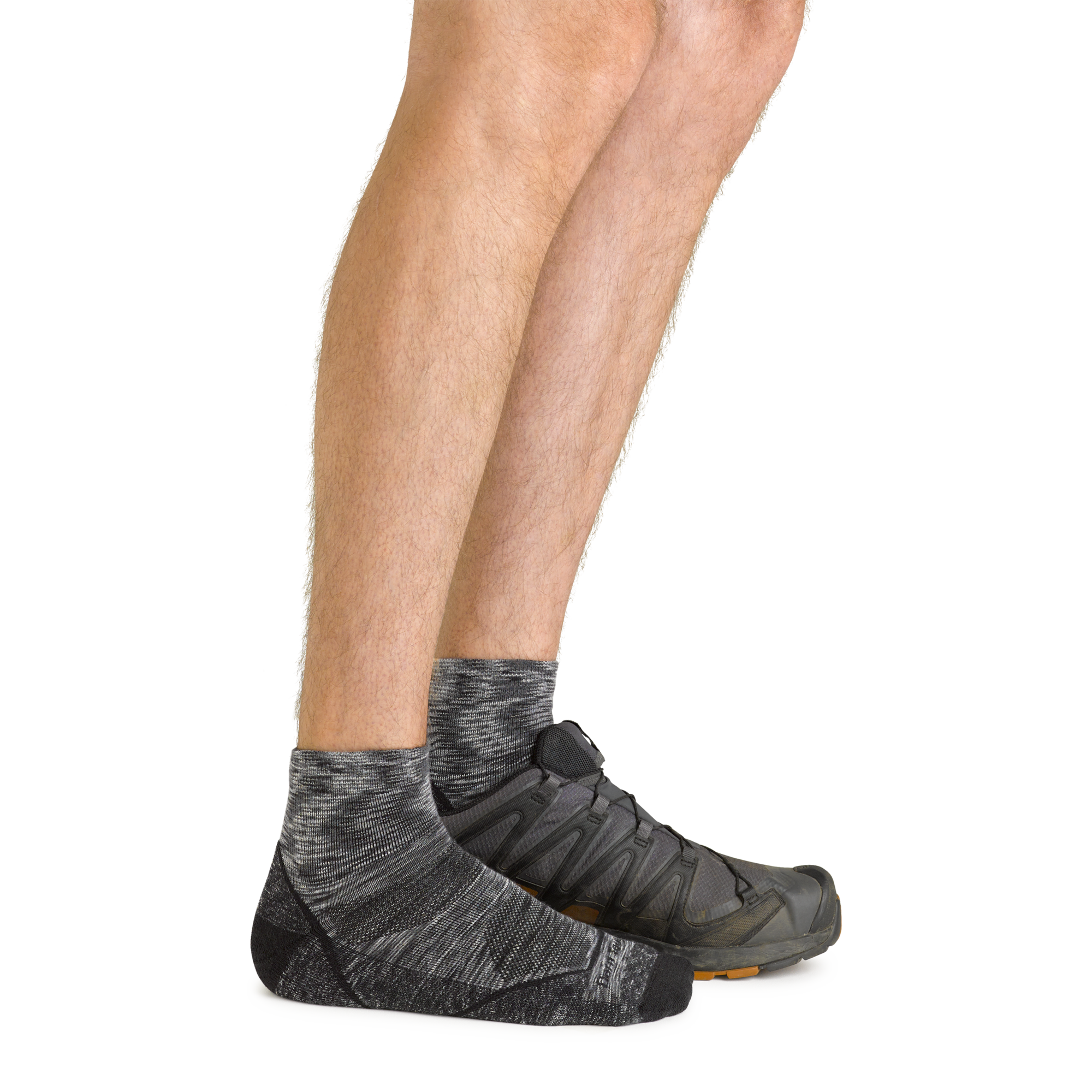 Side shot of model wearing the men's light hiker quarter hiking sock in space gray with a gray shoe on his left foot
