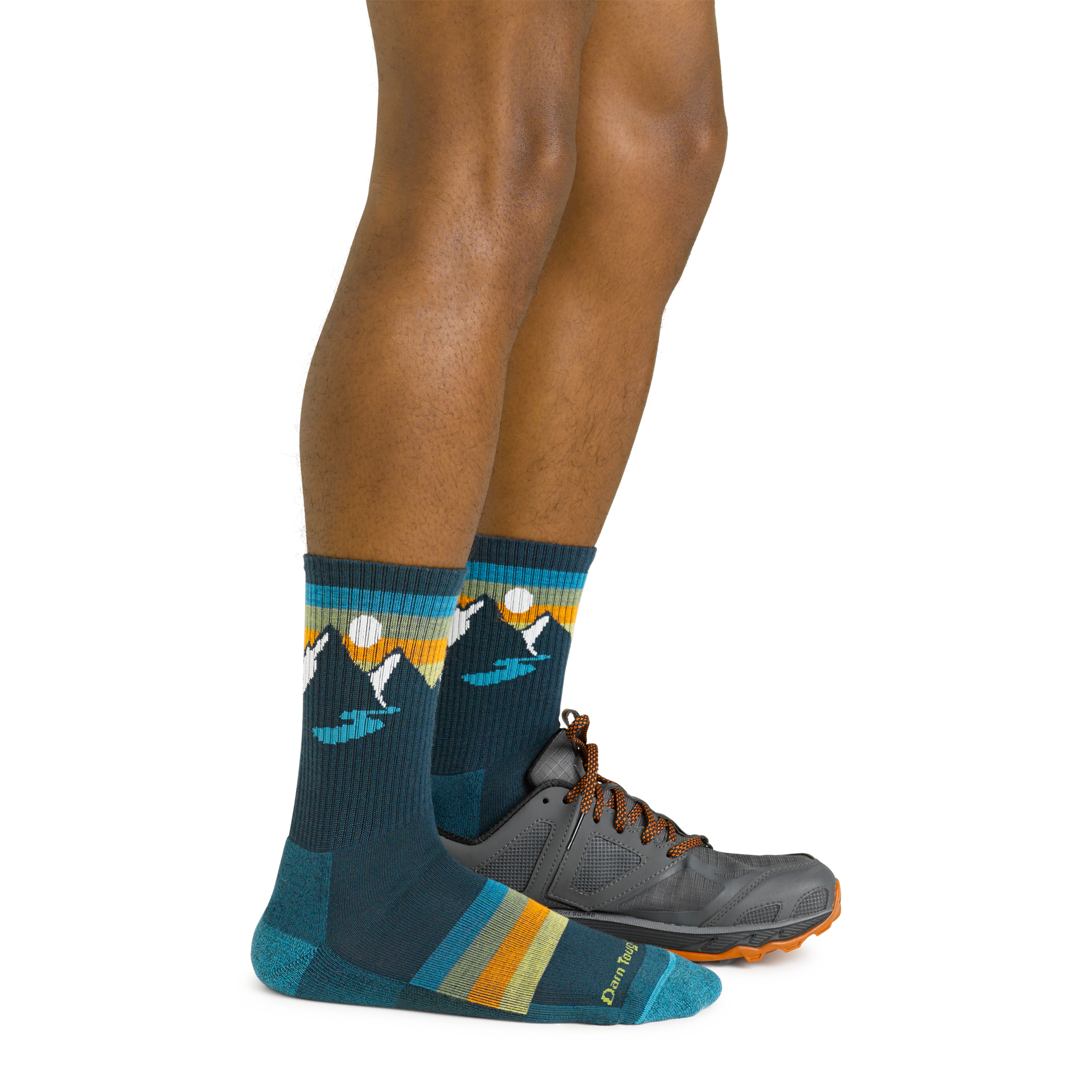 Model wearing the men's sunset ridge micro crew hiking sock in bottle blue with a gray sneaker on his left foot