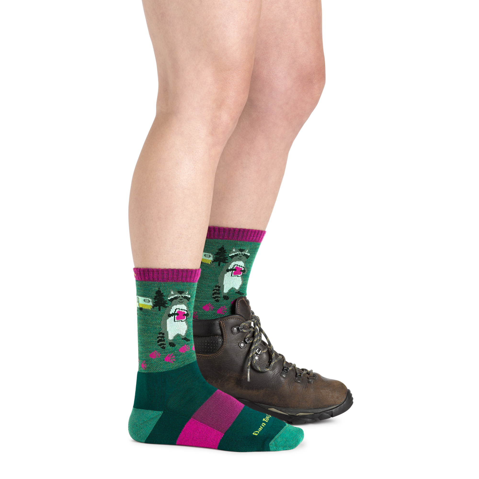 Side shot of model wearing the women's critter club micro crew hiking sock in Moss green with a brown boot on her left foot