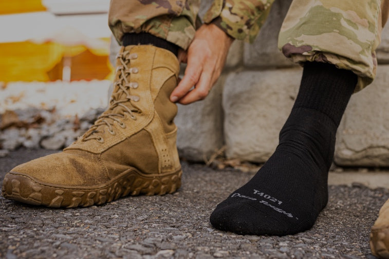 Shop Tactical Socks - feet wearing black Darn Tough socks with military combat boots