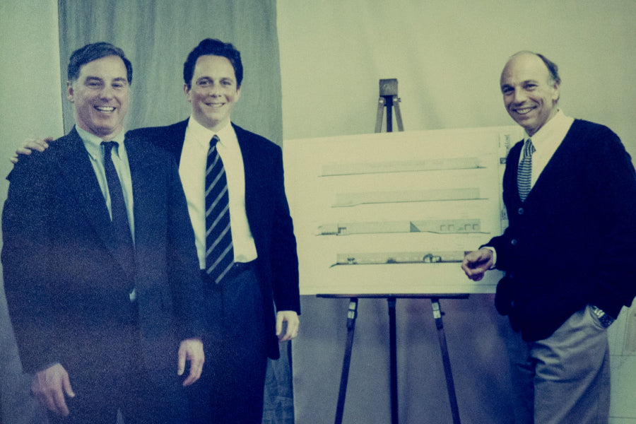 Ric, Marc, and a friend standing around plans for the new mill in Northfield