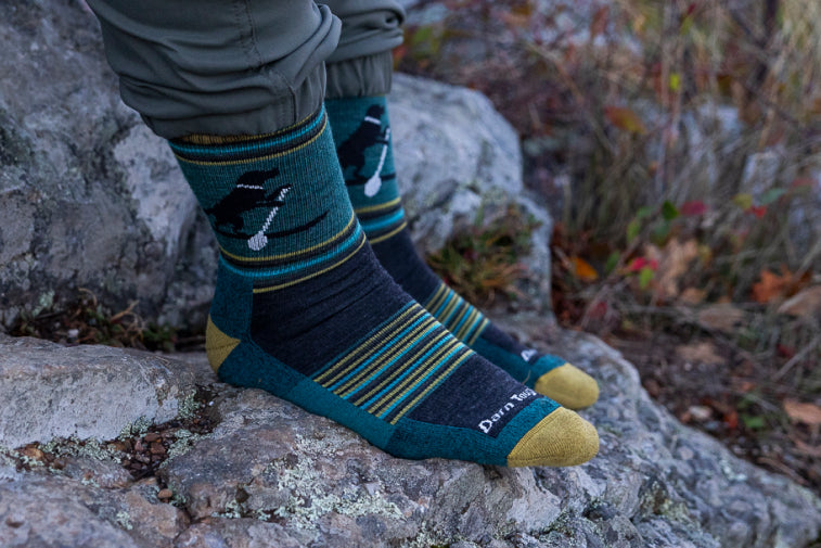 Feet wearing blue socks with a dog paddle boarding on them - a great gift for guys