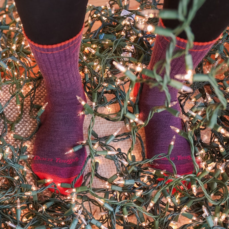 Darn it - a pair of feet in Darn Tough socks standing in a giant tangle of holiday lights