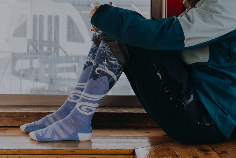 Shop Ski and Snowboard socks - feet in over the calf blue ski socks with swirling snow pattern